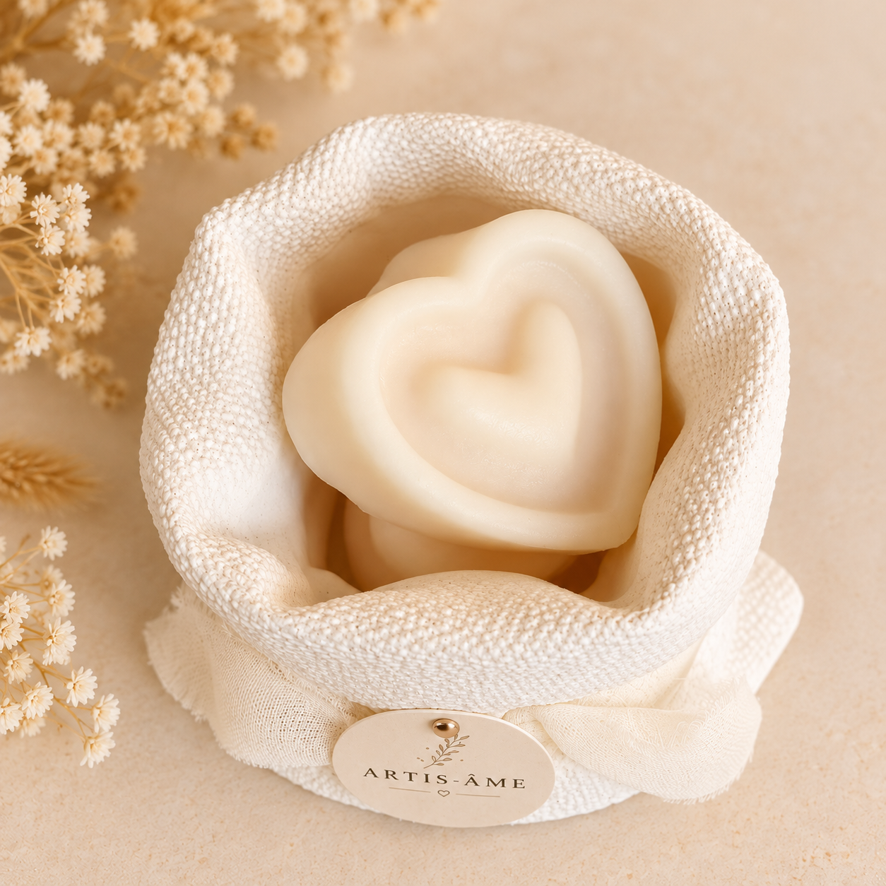 Vue de dessus du Nid Bohème Parfum ARTIS-ÂME, contenant deux fondants parfumés en forme de cœur de 15 g, dans un contenant artisanal en plâtre ivoire décoré d'un ruban en mousseline.